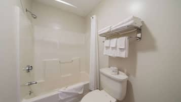 Un baño con bañera, inodoro y perchero para toallas.