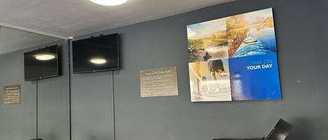 A gym with exercise equipment, a treadmill, and a wall-mounted TV.