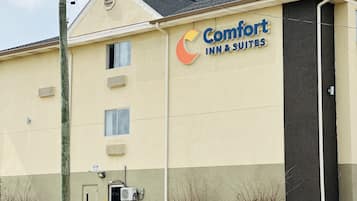 A Comfort Inn & Suites building with a beige facade, multiple windows, and a large sign displaying the logo.