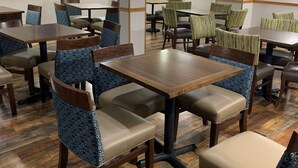 A restaurant with wooden tables and chairs, a patterned floor, and framed pictures on the walls. - Days Inn by Wyndham Custer (Custer)
