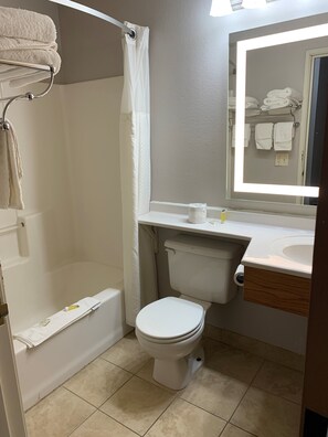 A bathroom with a bathtub, toilet, and sink.