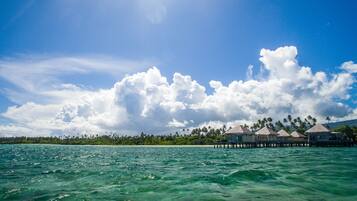 Blick auf die Küste mit überwasserbungalows und einem klaren Himmel.
