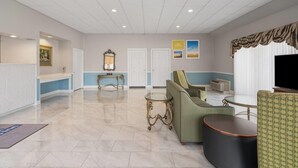 A spacious lobby with a reception desk, seating area, and a large flat-screen TV. - Days Inn by Wyndham Alma (Alma)