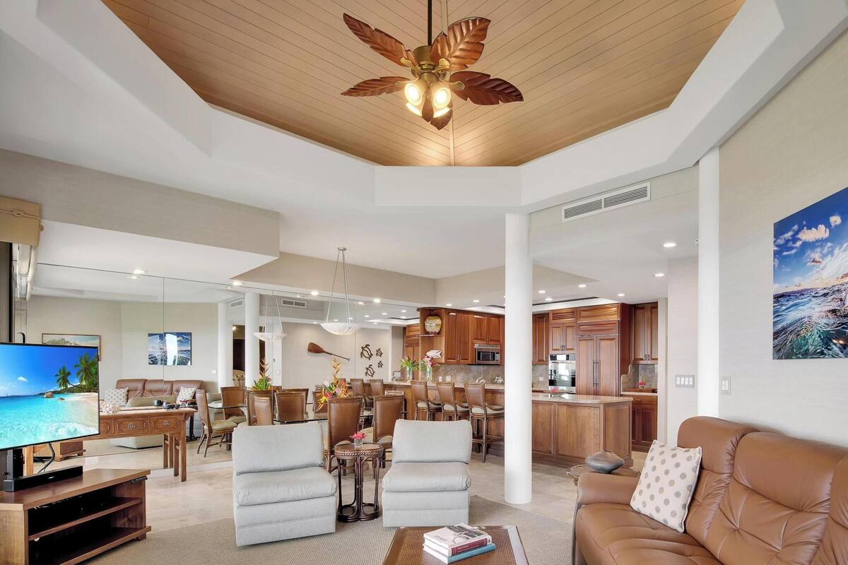 A spacious living area with a wooden ceiling, a dining area, and a kitchen.