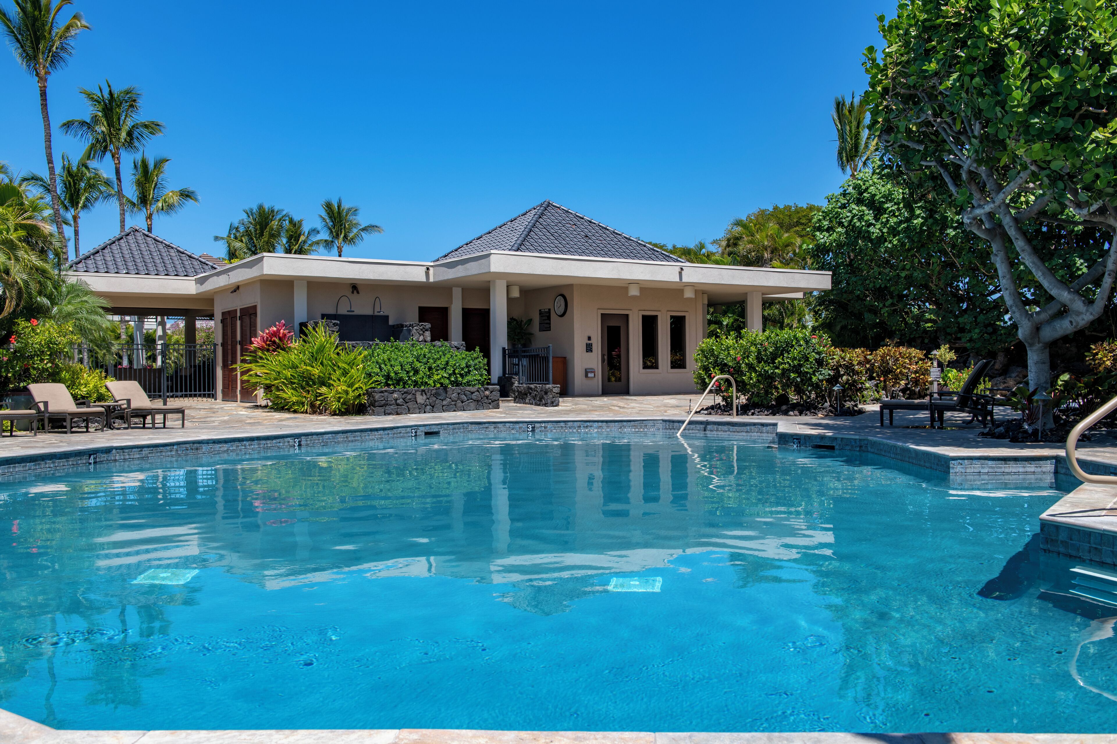 A pool area with a house in the background.