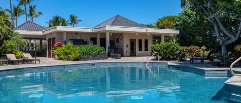 Zona de piscina con una casa al fondo.