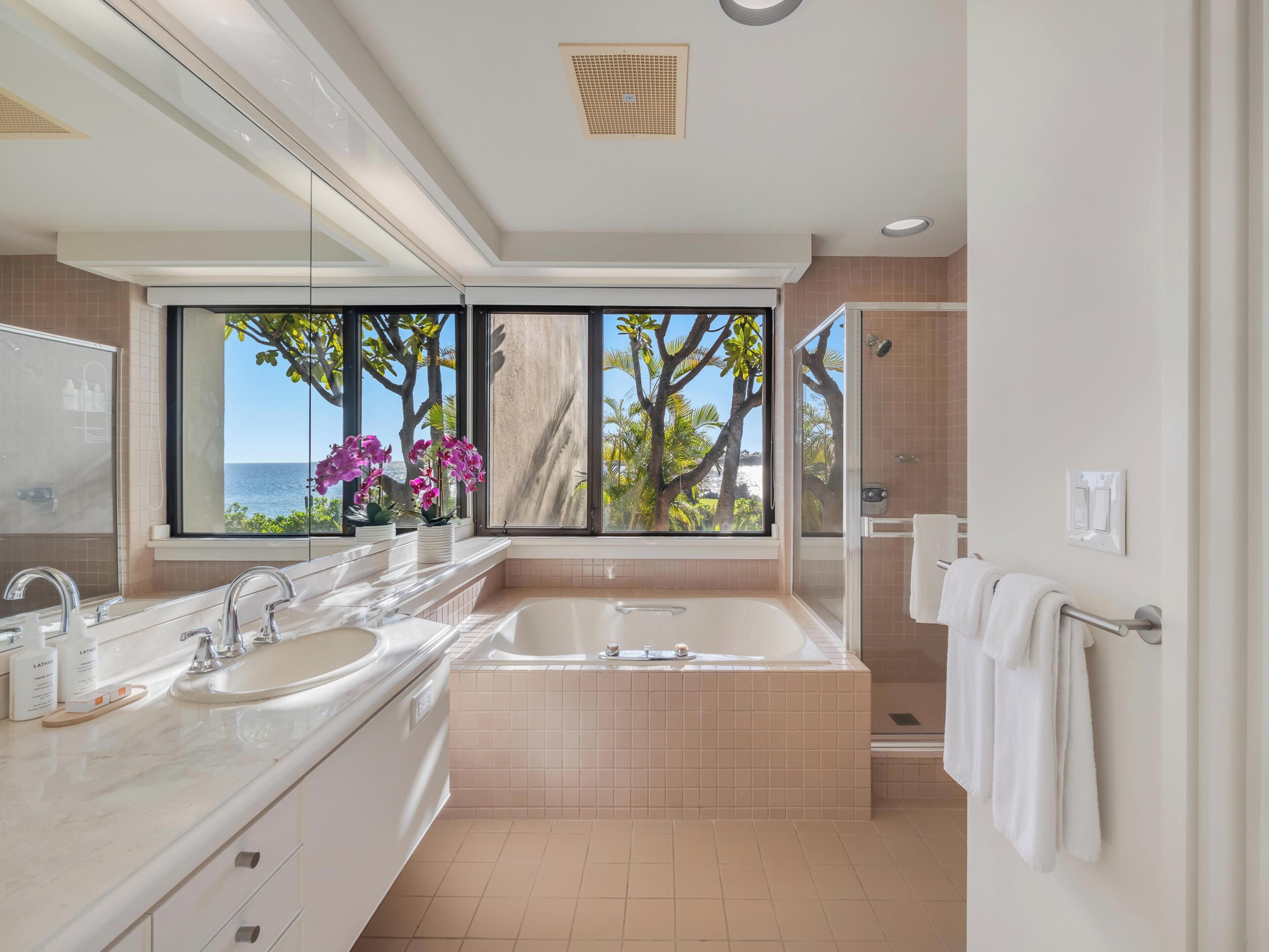A modern bathroom with a large window, a bathtub, and a shower.