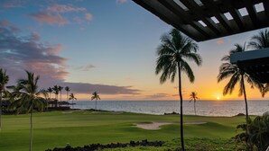 Un campo da golf con vista sull'oceano al tramonto.