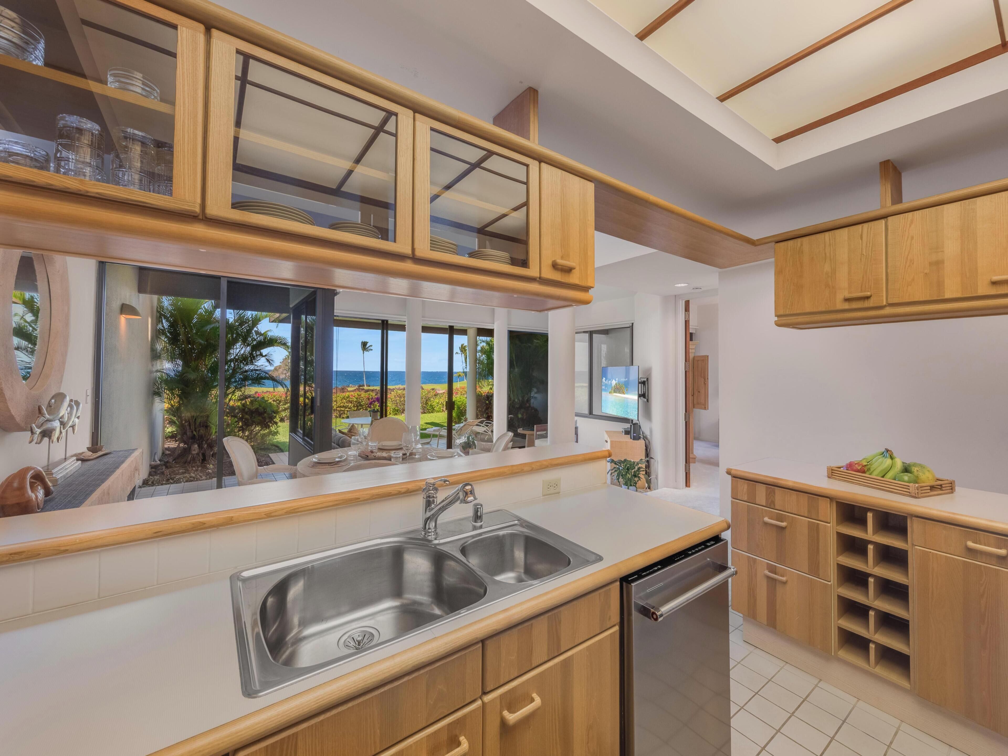 A modern kitchen with wooden cabinets, a stainless steel sink, and a built-in dishwasher.