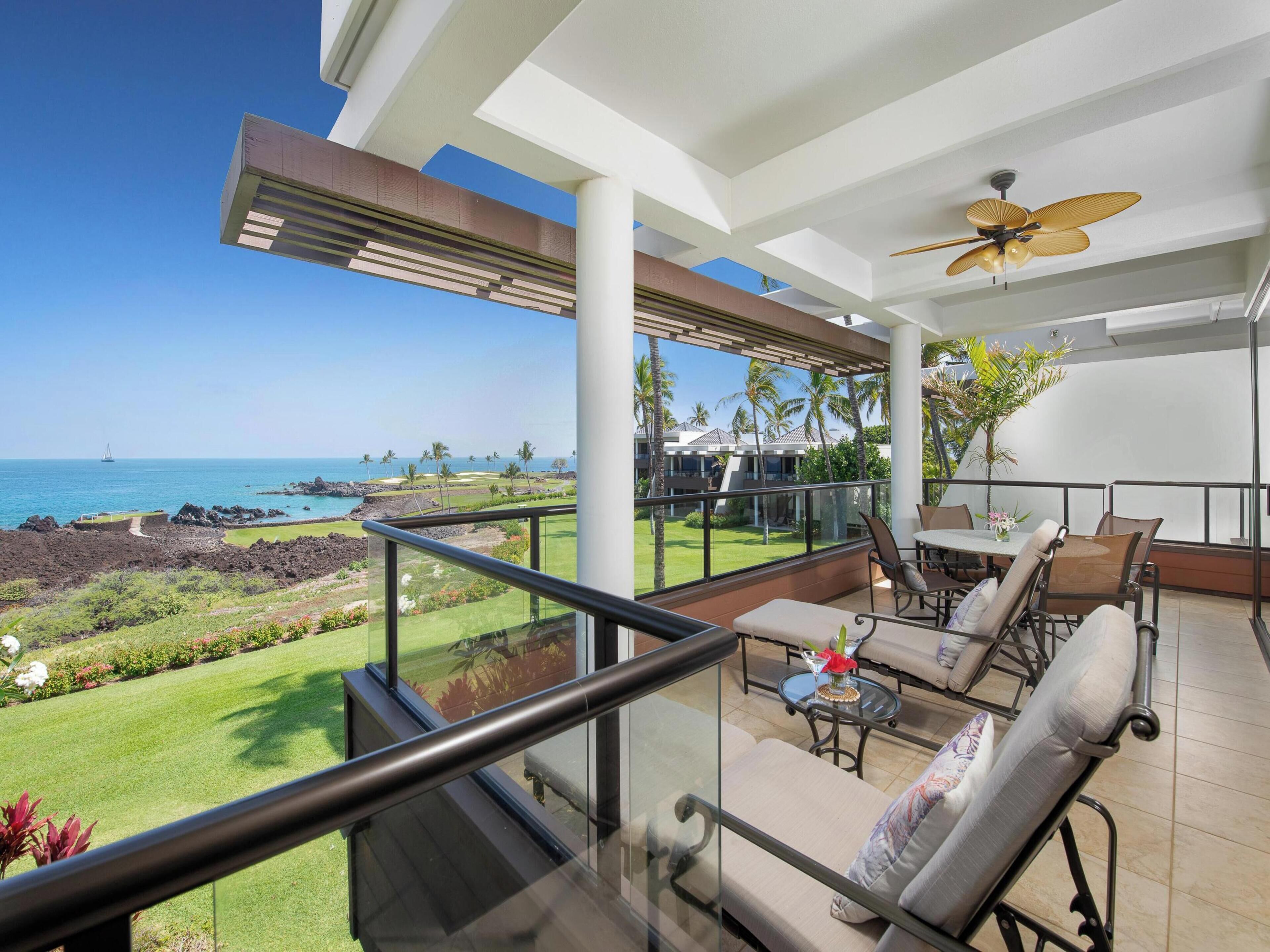 A balcony with a view of the ocean and a golf course.