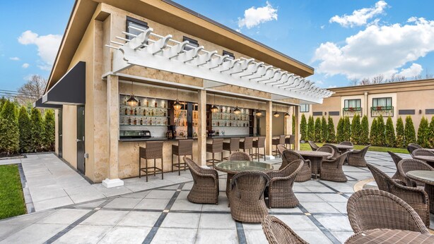 An outdoor bar area with wicker furniture and a pergola. - The Ashi, an Ascend Collection Hotel (North Brunswick)