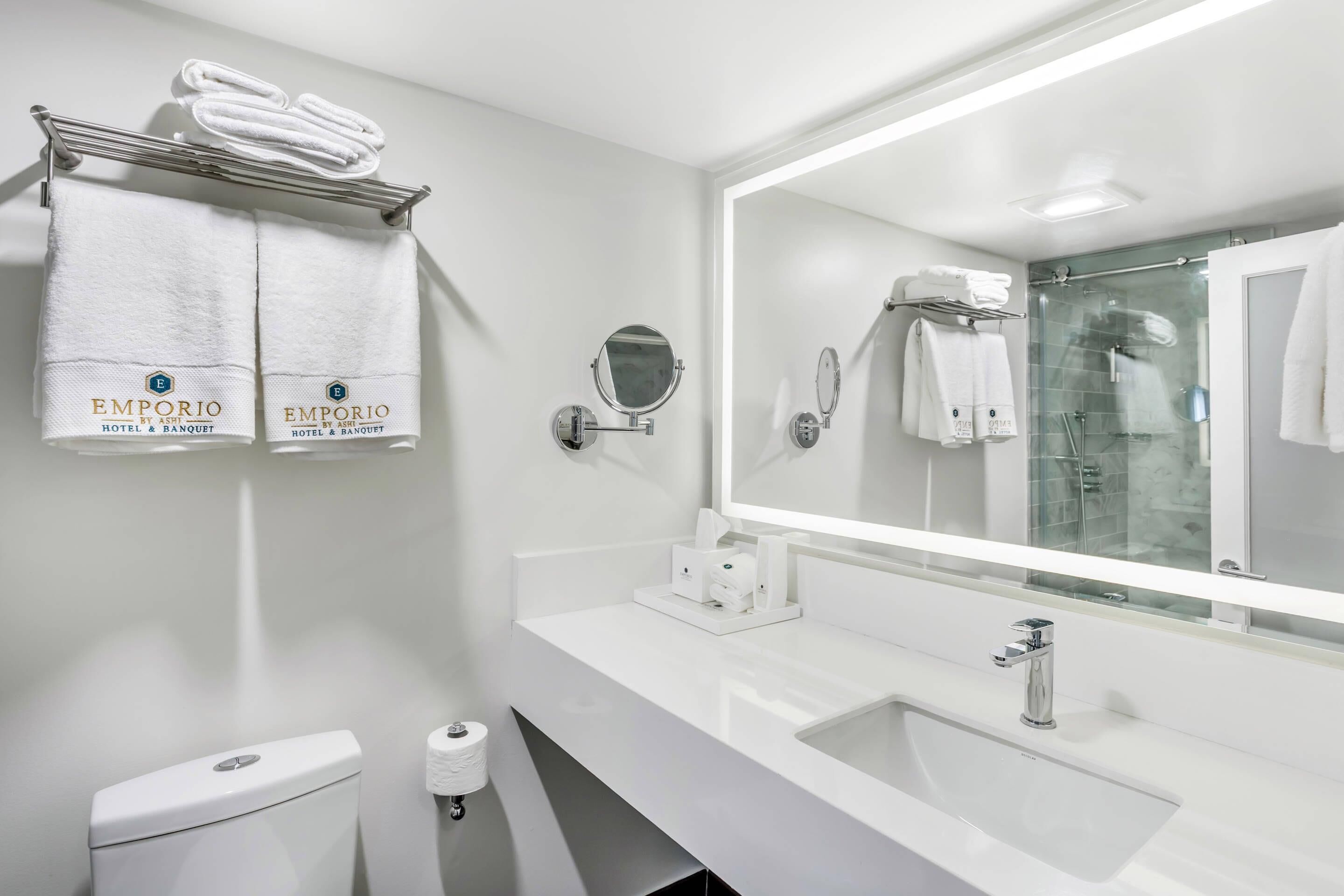 Un baño moderno con un espejo grande, dos lavamanos y un inodoro.
