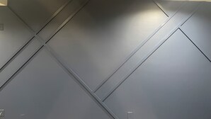 A ceiling with a recessed light fixture and a vent.