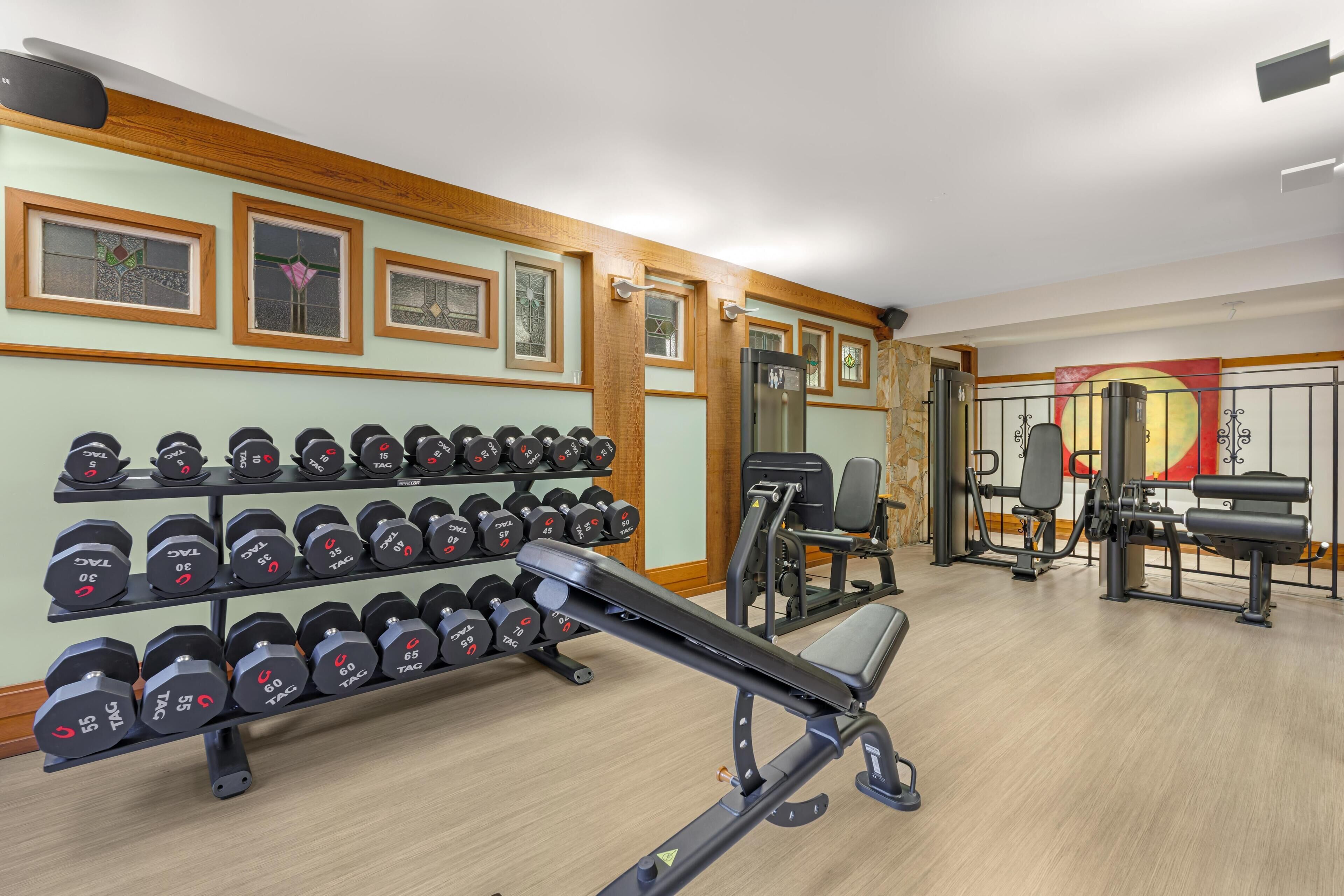 A gym with dumbbells, benches, and exercise equipment.