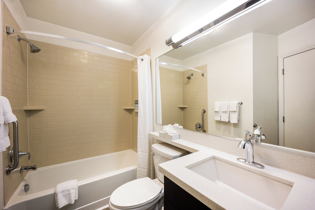 A modern bathroom with a bathtub, toilet, and sink.