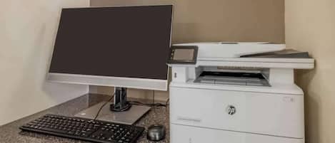 Een computer met monitor, toetsenbord en muis op een granieten aanrecht.