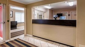 A reception area with a reception desk, a television, and a door leading to another room.