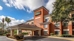 A Stay America hotel with a brick facade, a covered entrance, and a parking lot.
