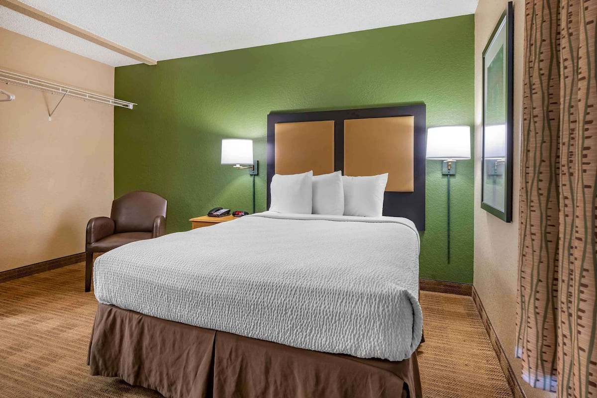 Escritorio, cortinas blackout y tabla de planchar con plancha