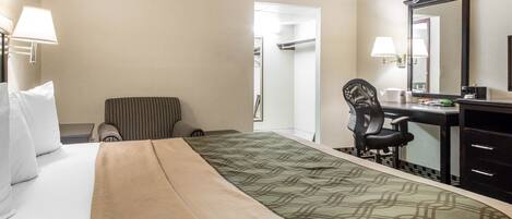Ein Hotelzimmer mit Bett, Schreibtisch, Stuhl und Kommode.