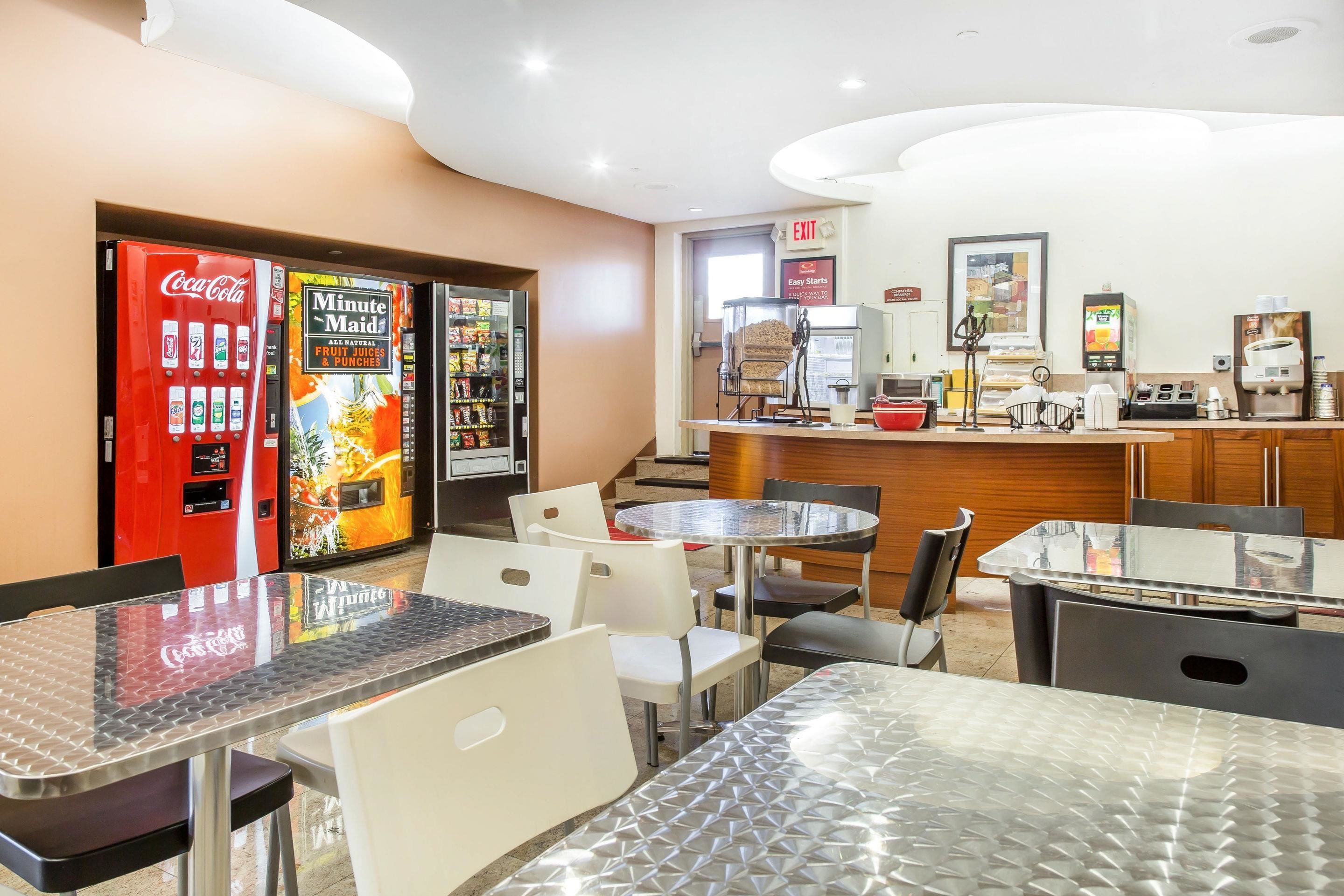 Eine Hotelhalle mit Verkaufsautomaten, einer Kaffeemaschine und einer Theke mit Speisekarte.