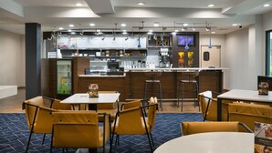Un restaurante moderno con zona de bar, diferentes disposiciones de asientos y una pantalla de menú.