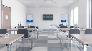 A conference room with tables, chairs, and a whiteboard. - Holiday Inn Express Luzern - Neuenkirch by IHG (Neuenkirch)
