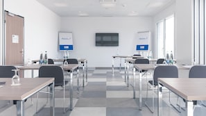 A conference room with tables, chairs, and a whiteboard. - Holiday Inn Express Luzern - Neuenkirch by IHG (Neuenkirch)