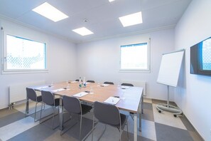A conference room with a long table, chairs, a whiteboard, and windows with blinds. - Holiday Inn Express Luzern - Neuenkirch by IHG (Neuenkirch)