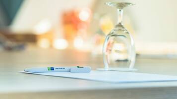 A pregnancy test and a glass of water on a white surface.