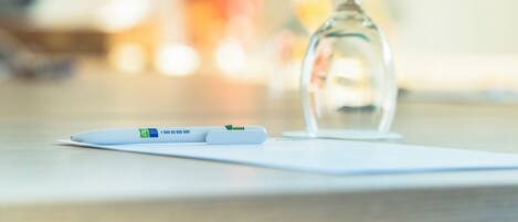 A pregnancy test and a glass of water on a white surface.