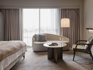 A modern hotel room with a bed, a sofa, a round table with two glasses, and a floor lamp. - The Playford Adelaide MGallery (Adelaide)
