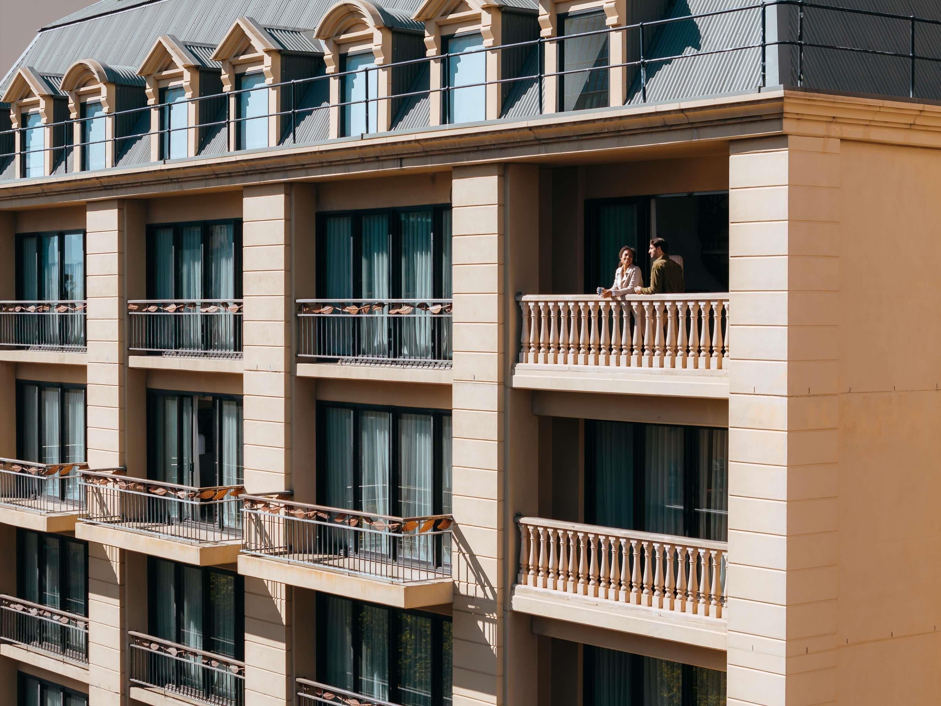 A multi-story hotel with balconies and large windows.
