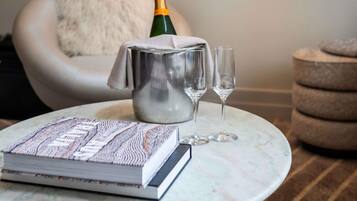 Une table en marbre avec un livre, une bouteille de champagne et deux verres.