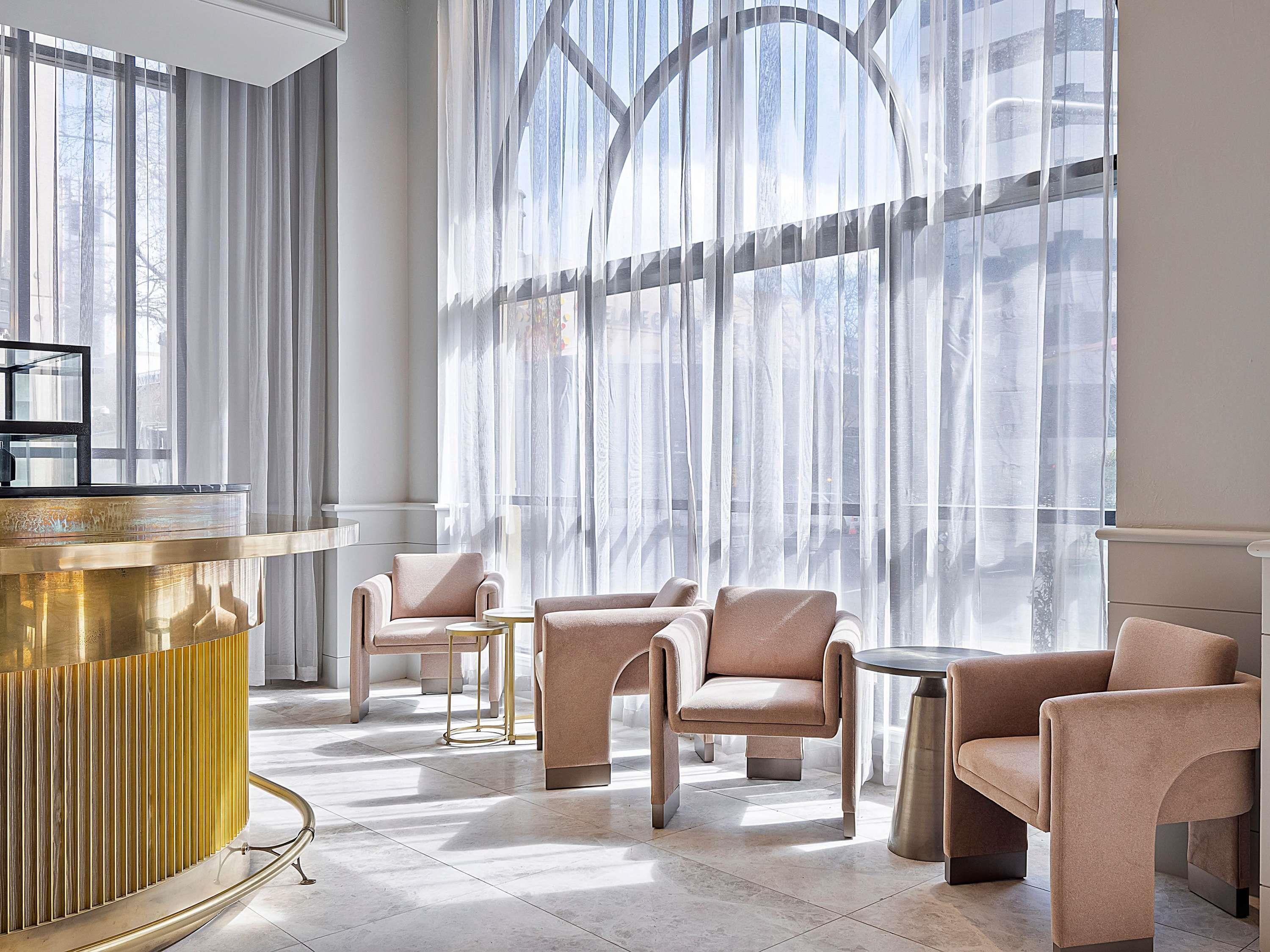 A modern interior with a reception desk, seating area, and large windows.