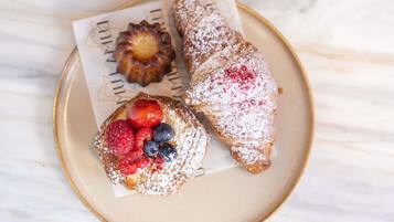 A plate with pastries and a small tart, both dusted with powdered sugar.