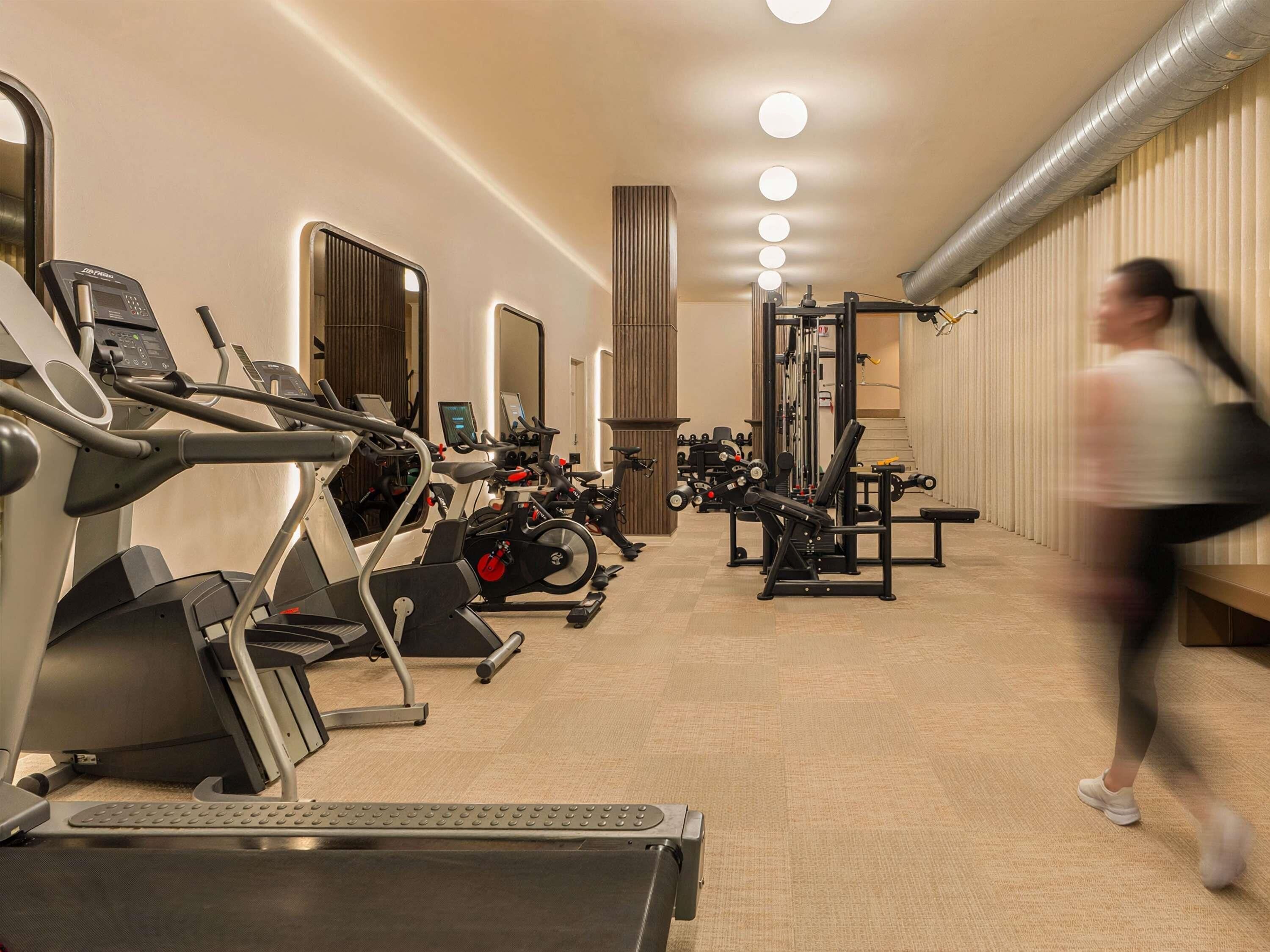 A gym with treadmills, stationary bikes, and weight machines.
