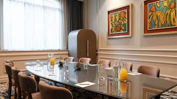 A conference room with a glass table, chairs, and artwork on the walls.