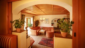 Ein gemütliches Wohnzimmer mit einer Couch, einem Couchtisch und Topfpflanzen.