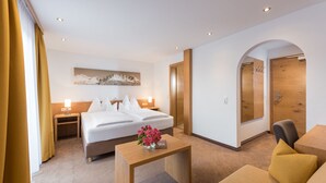 Ein Hotelzimmer mit Bett, Nachttischen, Schreibtisch, Stuhl und einer Tür.