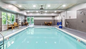 A swimming pool with a tiled edge, wooden chairs, and tables around it. - Country Inn & Suites by Radisson, Annapolis, MD (Annapolis)