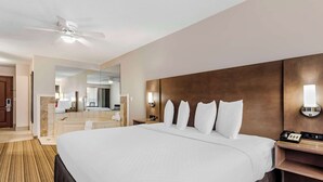 A hotel room with a large bed, a bedside table with a lamp, a phone, a mirror, and a bathroom with a bathtub and toilet. - Country Inn & Suites by Radisson, Annapolis, MD (Annapolis)