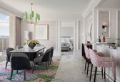 A modern hotel room with a dining area, a kitchen, and a bedroom.