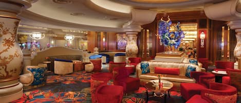 Un hall d’entrée luxueux, doté de sièges confortables, de vases décoratifs et d’un tapis aux couleurs vives.