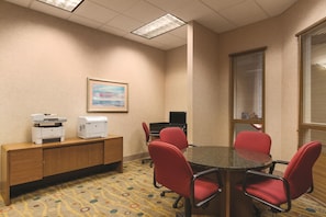 A conference room with a round table, four red chairs, a wooden cabinet with printers, a framed picture on the wall, and a window with blinds. - Embassy Suites by Hilton Portland Airport (Portland)