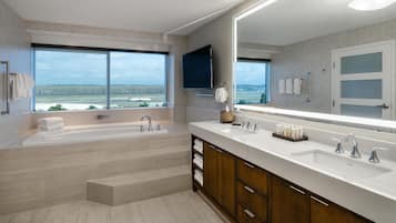 Un baño moderno con una bañera grande, dos lavamanos y un espejo amplio.