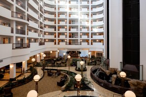 A multi-level hotel lobby with a central atrium, seating areas, and a waterfall feature. - Embassy Suites by Hilton Portland Airport (Portland)