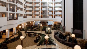 A multi-level hotel interior with a central atrium, multiple balconies, and a waterfall feature. - Embassy Suites by Hilton Portland Airport (Portland)