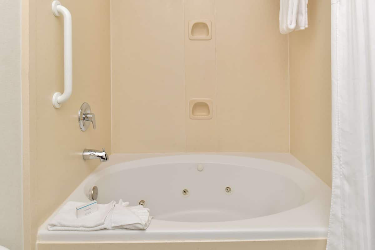 room, 1 king bed with sofa bed, jetted tub | bathroom | hair dryer, towels