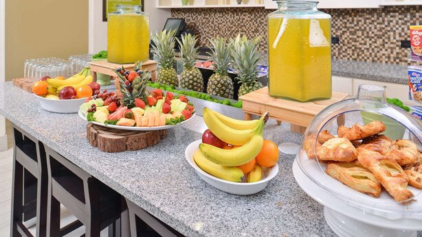 Un buffet de petit-déjeuner proposant une variété de fruits, de viennoiseries et de boissons.